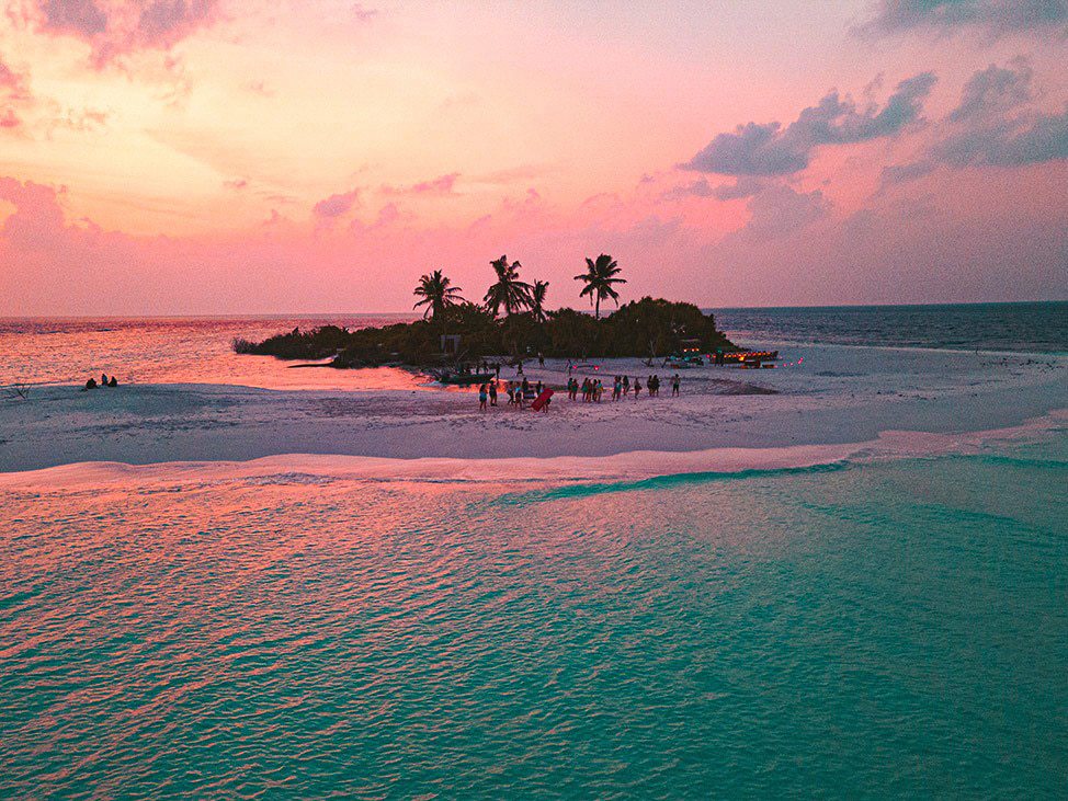 People on the beach of a small island at sunset