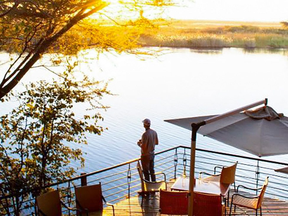 Man overlooking water with sunset in background Botswana