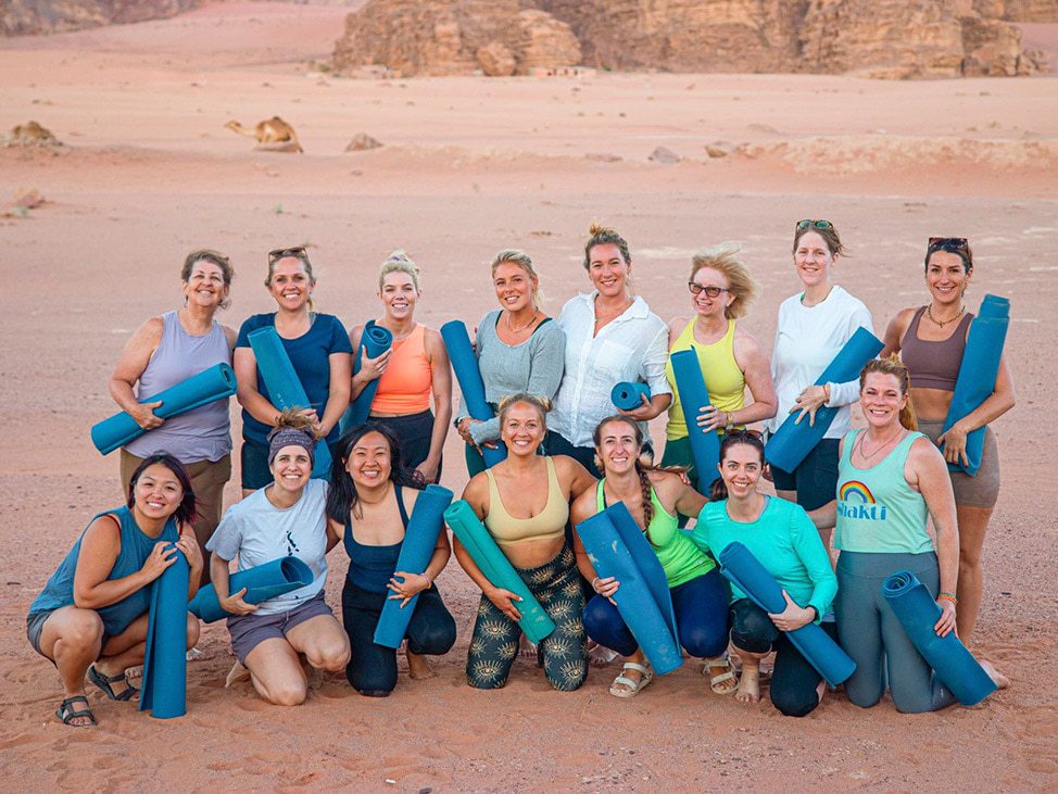 Wander Women with yoga mats in dessert