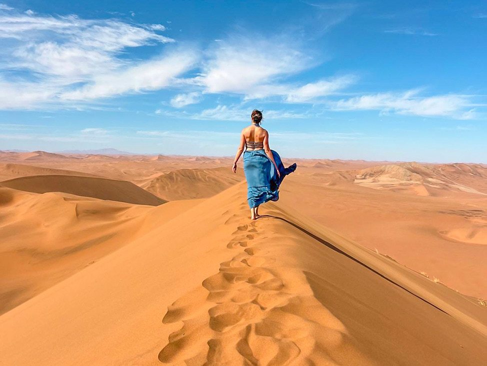 Woman walking on sand dune Namibia