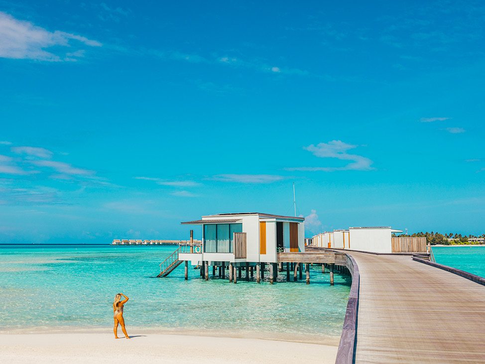 Woman on the beach near Overwater Bungalows in the Maldives