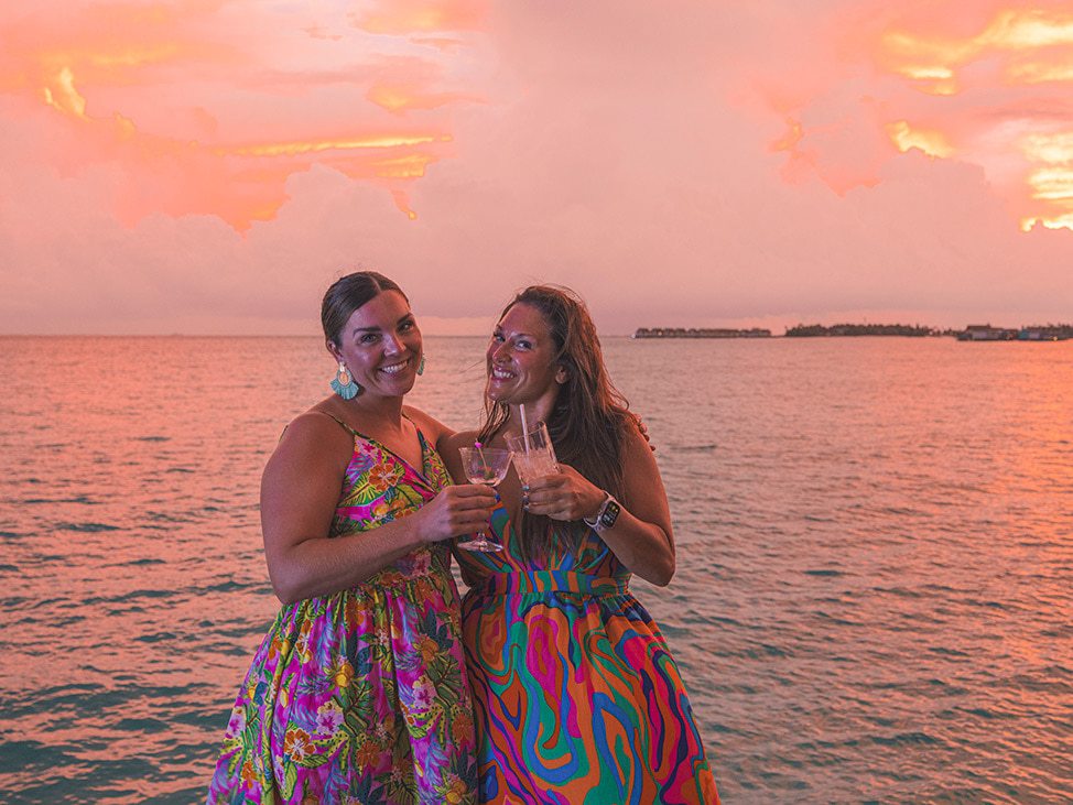 Two women on retreat at sunset in the Maldives