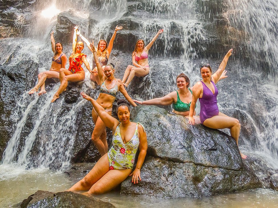 Wander Women women's retreat posing in a waterfall